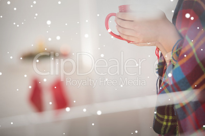 Composite image of woman with cover holding mug