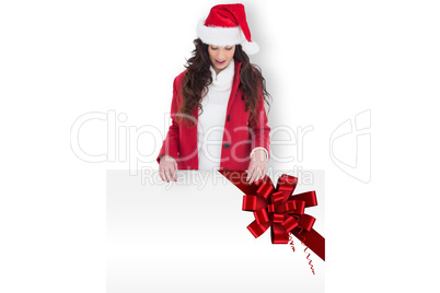 Composite image of festive brunette showing white poster
