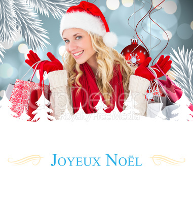 Composite image of happy festive blonde with shopping bags