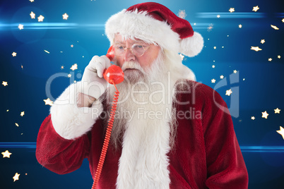 Composite image of santa on his red phone