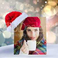 Composite image of brunette with cover holding mug