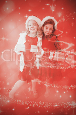 Composite image of festive little girls smiling at camera with g