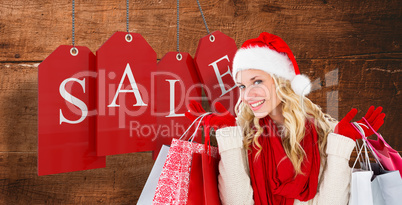 Composite image of happy festive blonde with shopping bags