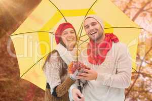 Composite image of autumn couple holding umbrella