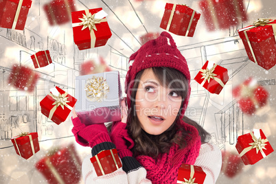 Composite image of young woman shaking her gift in order to gues