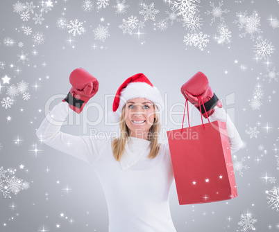 Composite image of festive blonde in boxing gloves with shopping