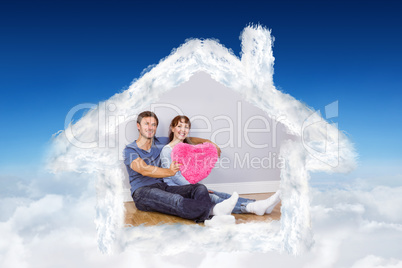 Composite image of couple holding a large heart