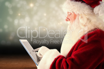 Composite image of santa uses a tablet pc