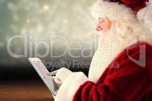 Composite image of santa uses a tablet pc