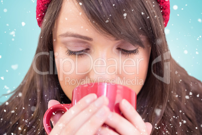 Composite image of close up of a festive brunette drinking from