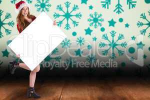 Composite image of festive redhead smiling at camera holding pos