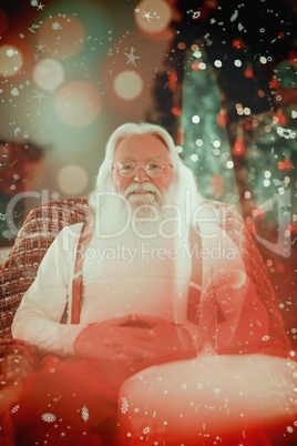 Composite image of smiling santa without his jacket relaxing