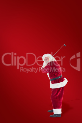 Composite image of santa claus swings his golf club