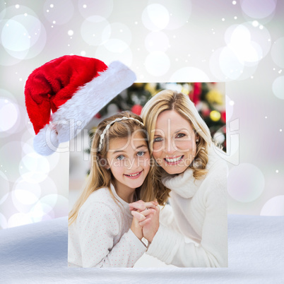 Composite image of festive mother and daughter beside christmas