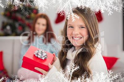 Composite image of festive little girl holding a gift