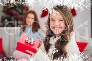 Composite image of festive little girl holding a gift