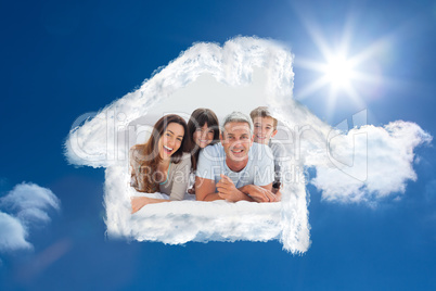 Composite image of happy family lying together