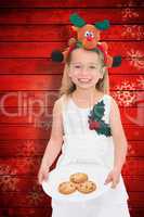 Composite image of festive little girl holding fresh cookies
