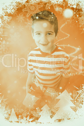 Composite image of festive little boy holding a gift