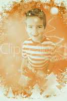 Composite image of festive little boy holding a gift