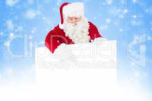 Composite image of cheerful santa claus presenting sign