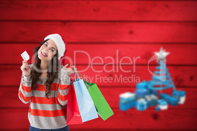 Composite image of smiling brunette holding credit card and shop