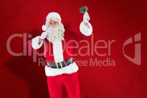 Composite image of santa claus holding a sack and bell