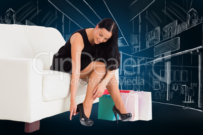 Composite image of woman sitting with shopping bags