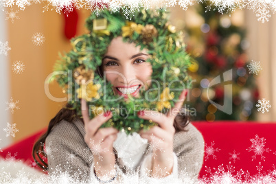 Composite image of brunette on the couch showing wreath at chris