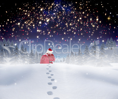 Composite image of santa walking in the snow