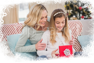 Composite image of daughter opening christmas gift with mother