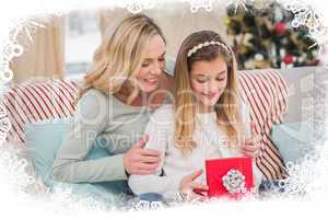 Composite image of daughter opening christmas gift with mother