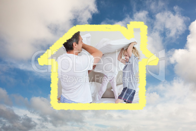 Composite image of family having a pillow fight