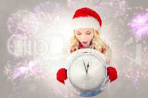 Composite image of festive blonde holding large clock
