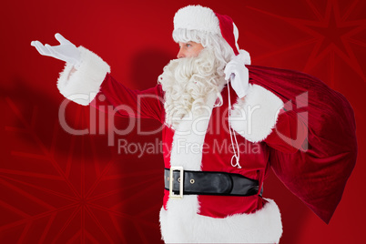 Composite image of santa with hand out and holding sack