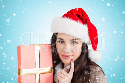 Composite image of festive brunette holding gift