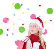 Composite image of happy festive blonde with shopping bag