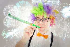 Composite image of geeky hipster wearing a rainbow wig blowing p