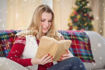 Composite image of pretty blonde reading book at christmas time