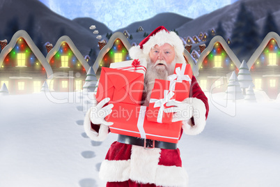 Composite image of santa carrying gifts in the snow