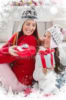 Composite image of mother and daughter exchanging gifts at christmas