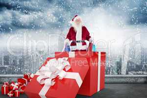 Composite image of santa standing in large gift