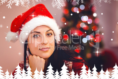 Composite image of festive brunette wearing a santa hat