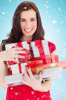 Composite image of smiling brunette holding many gifts