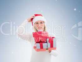 Confused blonde in santa hat holding gifts