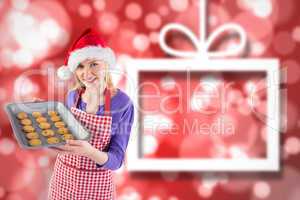 Composite image of festive blonde showing hot cookies