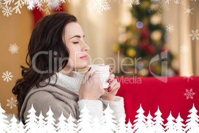 Composite image of brunette enjoying a hot chocolate at christma