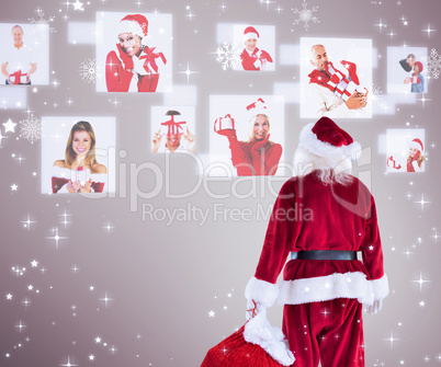 Composite image of santa carrying sack of gifts