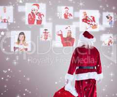 Composite image of santa carrying sack of gifts
