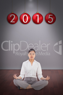 Composite image of businesswoman sitting in lotus pose
